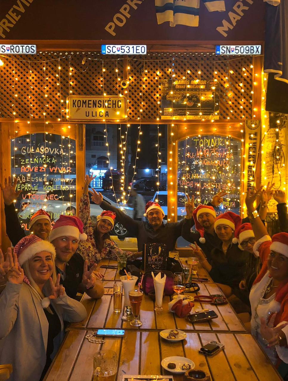 Friends celebrating at Praha Cafe with Santa hats